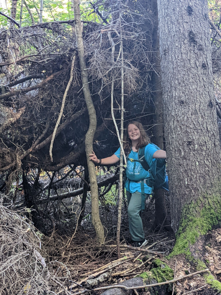 Fiona under the roots of a fallen tree