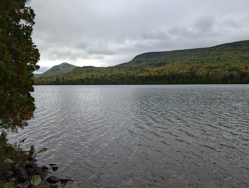 Slightly ripply lake with two mountains in the background