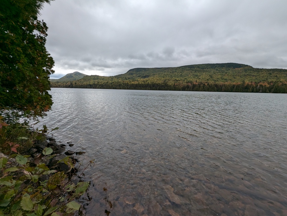 Slightly ripply lake with two mountains in the background