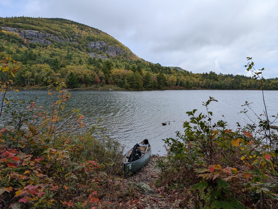 Lake with canoe in foreground and mountain in background