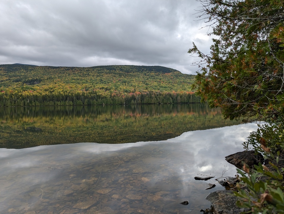 Panorama of calm lake with mountain in background and reflected on lake