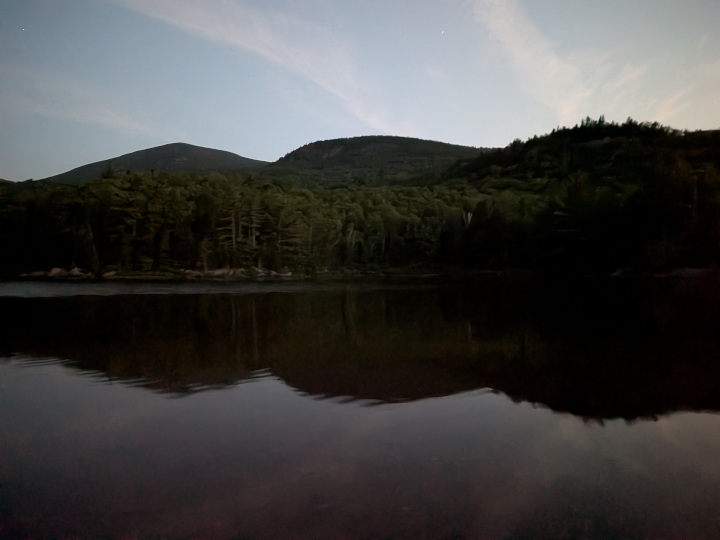 North Traveler Mountain and Barrel Ridge reflected on very calm Middle Fowler Pond after dark