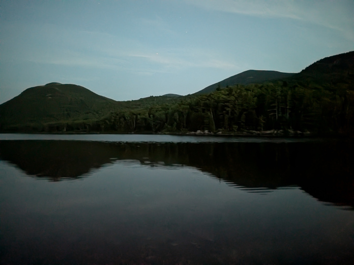Bald Mountain and North Traveler Mountain reflected on very calm Middle Fowler Pond after dark